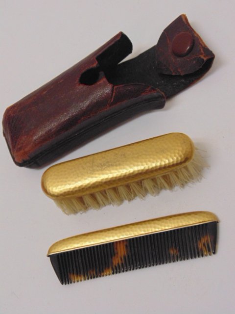 18K gold miniature brush & comb in leather pouch: 18K gold miniature brush & comb in leather pouch. Note, all property herein offered for sale is strictly "as is", and it is the bidder's responsibility, whether bidding in person, by mail, by e-mail o
