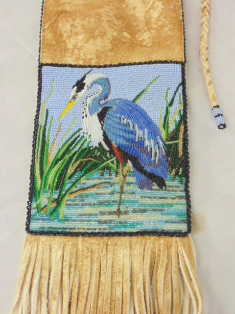 The Great Blue Heron pipebag, Pam Close, Shoshoni: The Great Blue Heron pipebag by Pam Close, Shoshoni, American Indian beadwork. Please refer to images for general condition issues. 19" by 5". 26" in length includes fringes.
