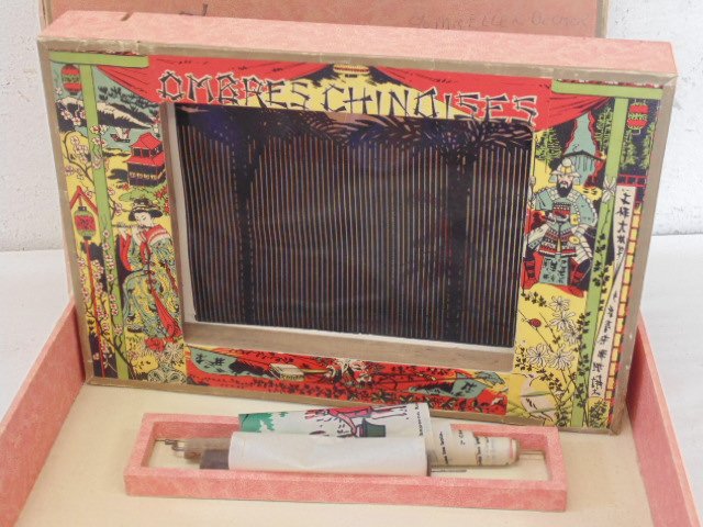 l'ombro-cinéma ombres chinoises: l'ombro-cinéma ombres chinoises optical game with 2 silhouette image rolls, film 21, "Histoire du chat Botte" & film22 "Histoire du Petit Chaperon Rouge", wind up mechanism seems stuck, box has been 