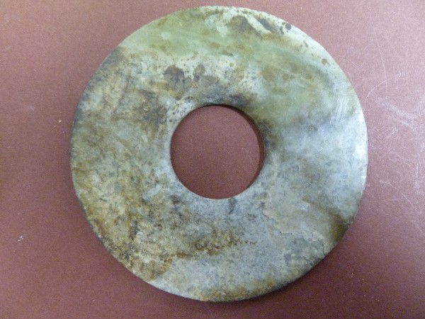 081: Silk Route Simplistic Bi: Gansu material, 4-1/8" diameter, 5/32" thick, the Bi was made from a slice near the surface of the ancient boulder so that the wispy cloud-type material makes up 2/3rds of the artifact. The large cent