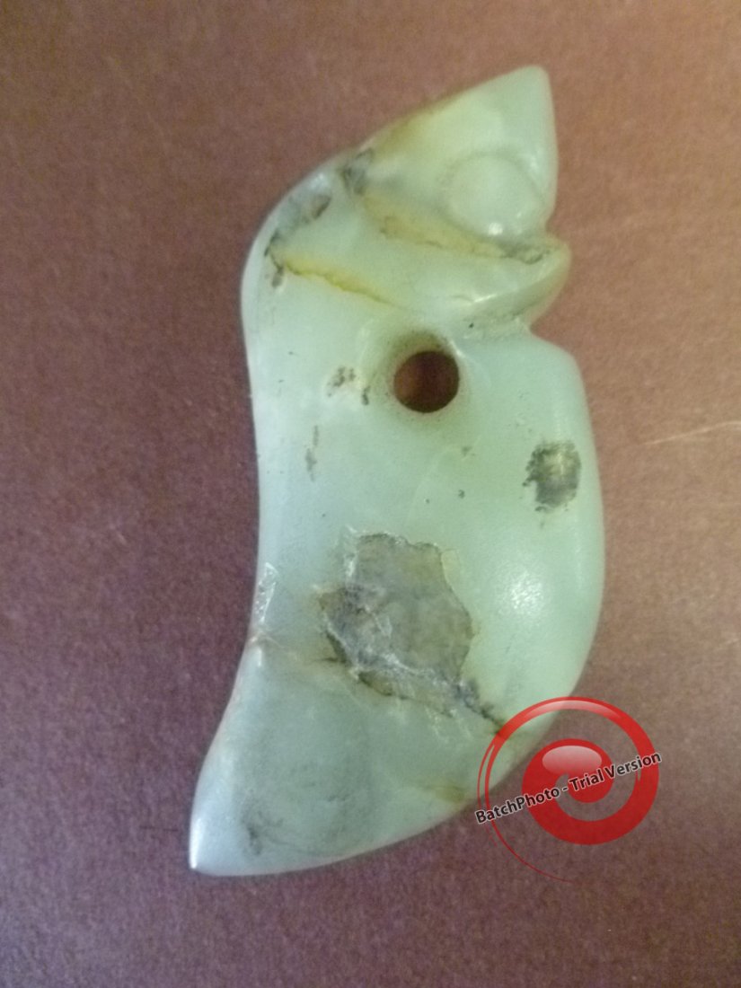 Rough Condition NEOLITHIC JADE: Likely worn by a rough Horseman, it got beat up like the dZi Beads of Tibet. A neat combination of a Dagger blade with the head of a young Dragon fetus, it has a large secondary hole that would have s
