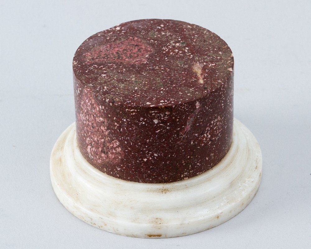 Porphyry stone base: Porphyry stone base, red colour with white incrustations; round cylindrical shape on stepped round white marble. 18th/19th Century. Notes: Sculptures Dimensions: Height 6.5cm, Diameter 10