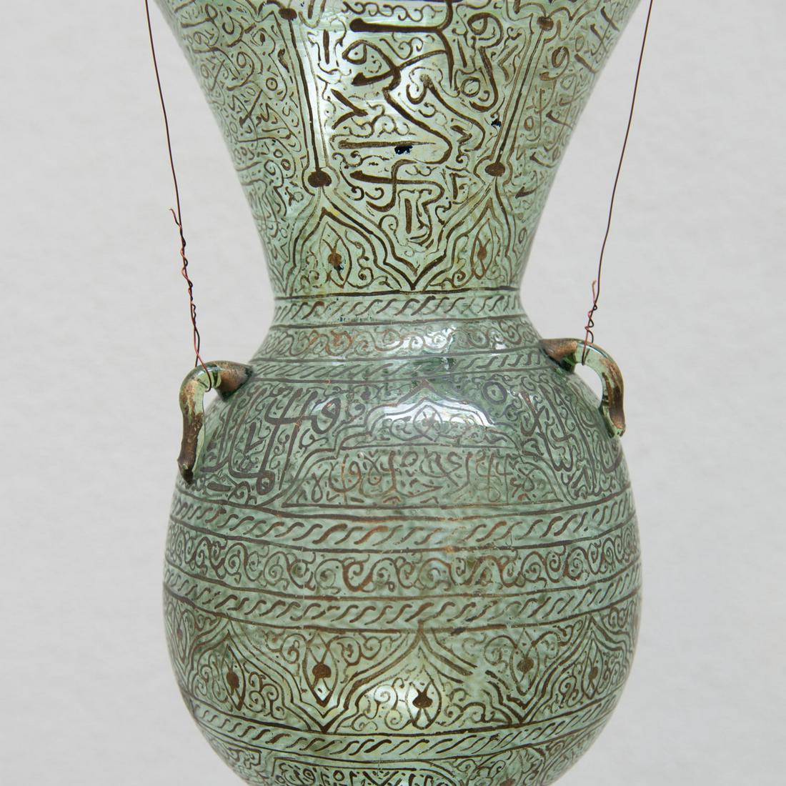 Patricular Mosque Lamp..: Patricular Mosque lamp., round, oval and zylindic shaped, with nob ending, 3 eyelets, mouth blown transparent glass with green glass with rich islamic decorations and calligraphy in gild colours, insi