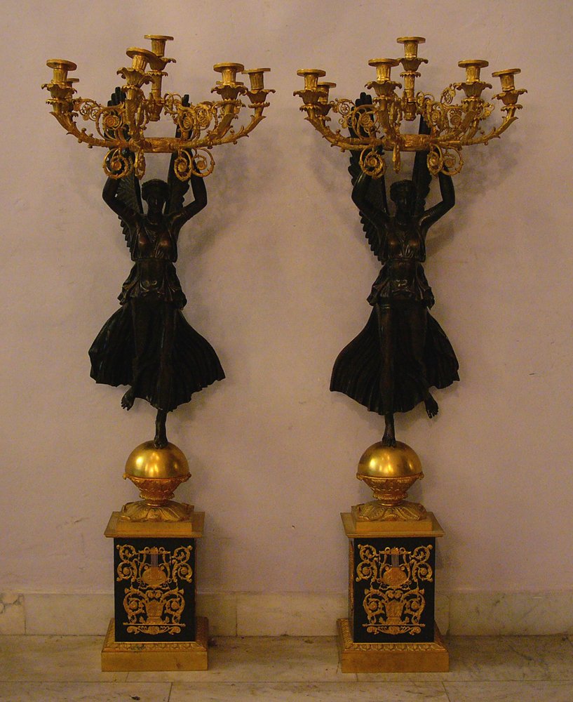 Pair of bronce candelabra in the manner of Pierre Phill: Pair of bronce candelabra in the manner of Pierre Phillipe Thomire (1751–1843), with standing bronce patinated angels holding a gilted ring with seven branches partly ruptured and decorated, four ca