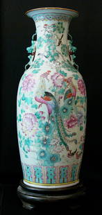 Chinese Porcelain Vase, with multicoloured bird and: Chinese Porcelain Vase, with multicoloured bird and flower decorations and two handgrips with Fo-lions, small neck and upper border, on carved wooden base. Signs of age. height 61,5cm