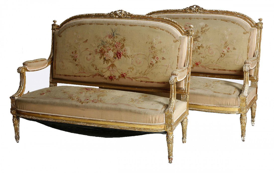 A pair of giltwood Settees, 19th century in the L: A pair of giltwood Settees, 19th century in the Louis XVI style, each with a ribbon moulded frame and ribbon bow crest and an arched and padded back and seat, covered in attractive Aubusson style fabr