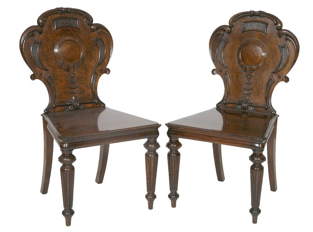 A pair of oak Hall Chairs, Victorian, by John Tay: A pair of oak Hall Chairs, Victorian, by John Taylor & Son, Edinburgh, stamped and numbered 4243, each with a cartouche shaped scroll back, above a solid seat on turned and tapering fluted legs. (2)