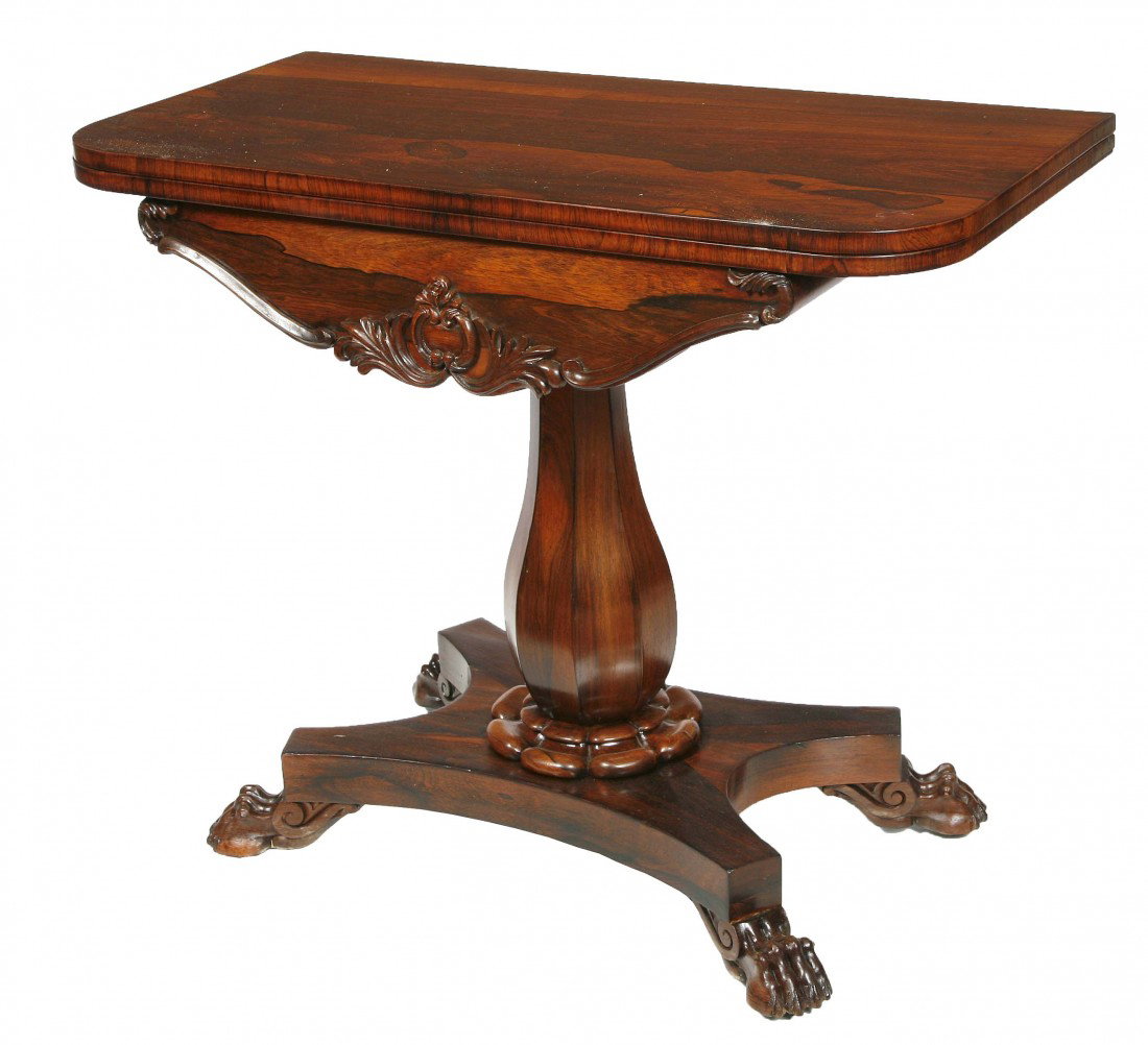 A good fold-over rosewood Card Table, William IV : A good fold-over rosewood Card Table, William IV period, the top with rounded corners and a baize lined interior, above a shaped frieze carved with a cartouche issuing leaves and scrolls, on an octago