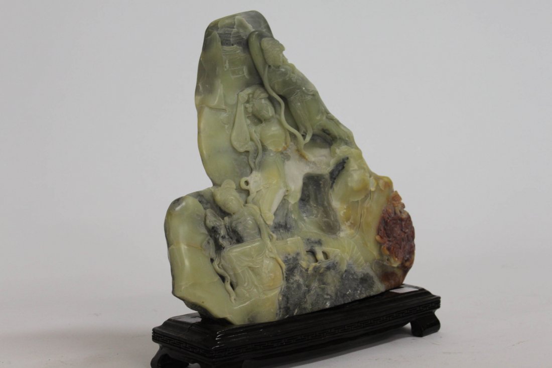 A carved Chinese soapstone relief with female fig: A carved Chinese soapstone relief with female figures in a landscape, 12" (30cms) x 12" (30cms). (1).
