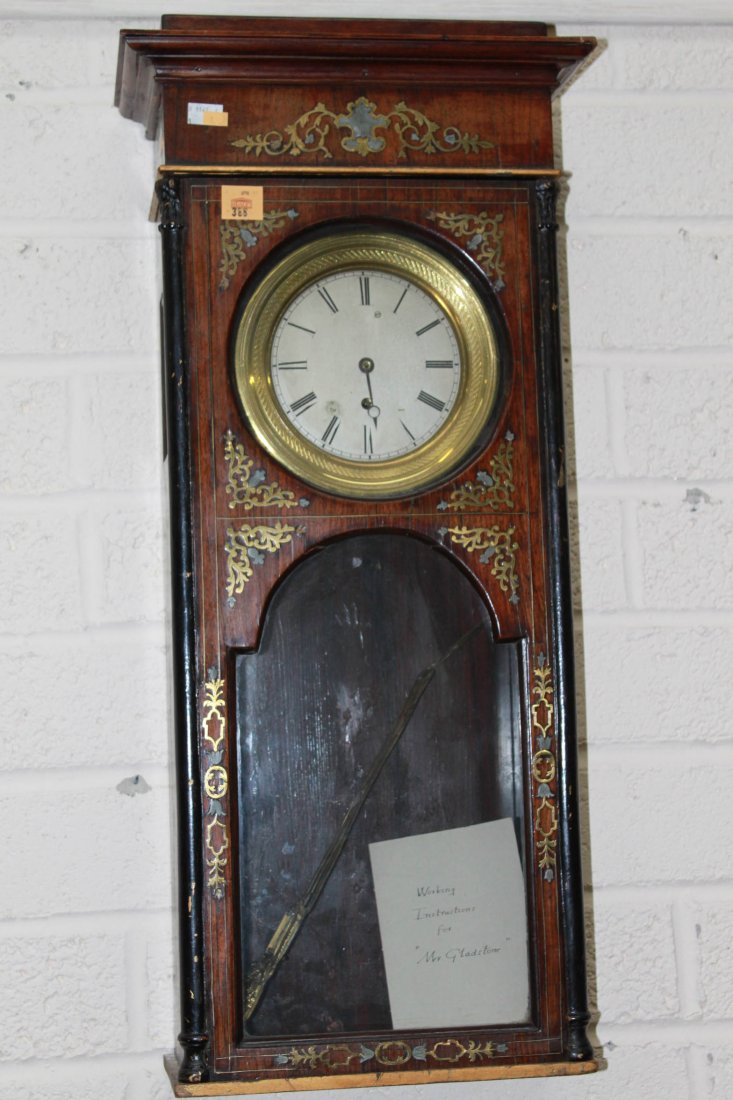 A brass and mother-o-pearl inlay Wall Clock, 19th : A brass and mother-o-pearl inlay Wall Clock, 19th Century, with ornate pendulum, the moulded cornice above a brass mounted silverized dial with Roman numerals and an arched glazed door, 32" x 14" (81c