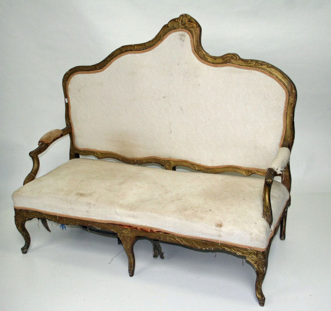 A pair of carved giltwood settees probably French,: A pair of carved giltwood settees probably French, 19th century, each with asymmetrical padded back and padded seat flanked with two shaped arm rests, on moulded cabriole legs, 58" (148cms). (2).
