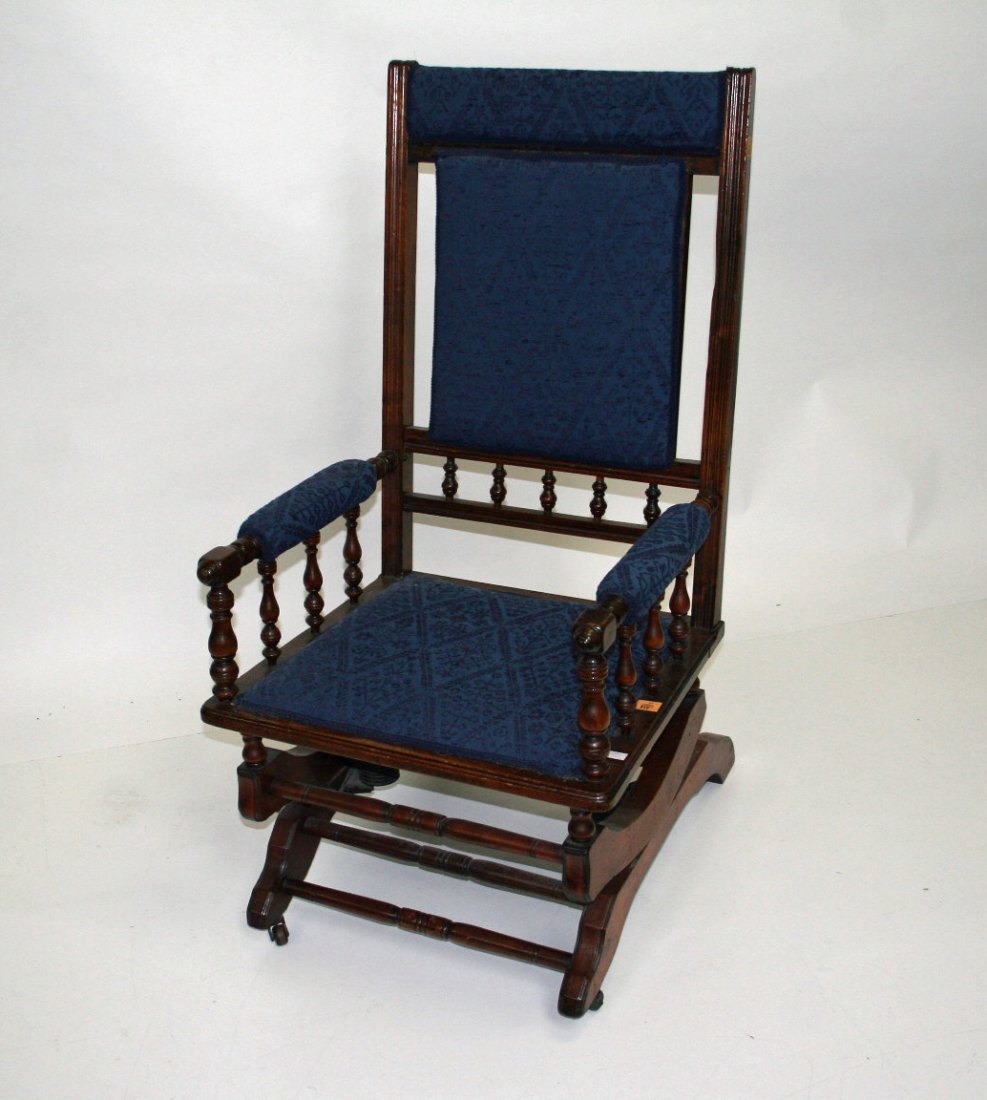 A walnut rocking chair, Edwardian, with padded sea: A walnut rocking chair, Edwardian, with padded seat and back, and baluster turned elbow rests. (1).