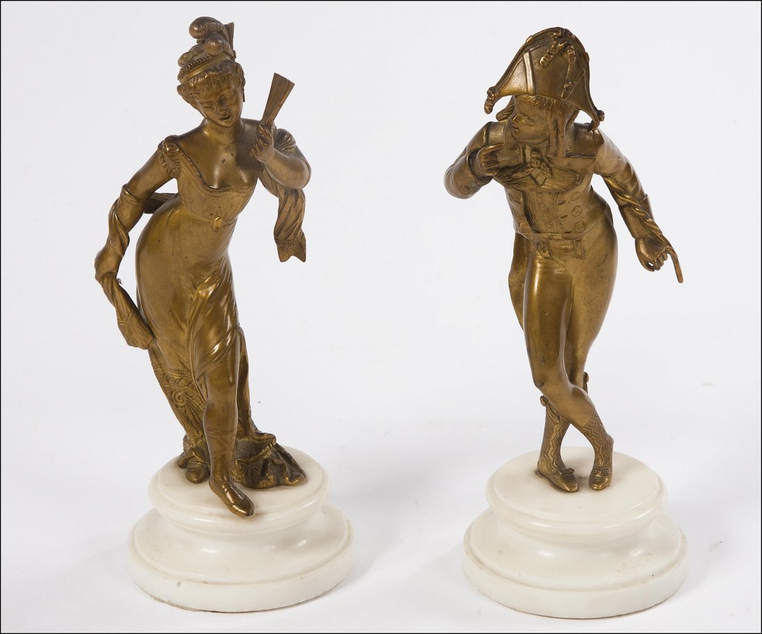 A gilt bronze figure of a lady, late 19th century,: A gilt bronze figure of a lady, late 19th century, in a ball gown, holding a fan and with feather hat; together with its companion, a gentleman with cocked hat, a pair, both on circular turned marble