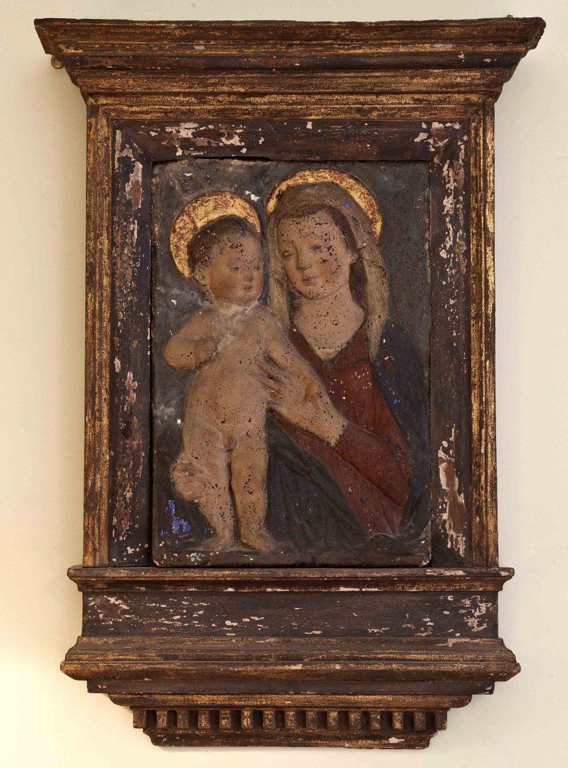 An early Italian painted stucco panel of the Virgi: An early Italian painted stucco panel of the Virgin and Child, contained within a green and gilt painted tabernacle style frame with moulded overhanging cornice, overpainted and restored, 39" x 24" (9