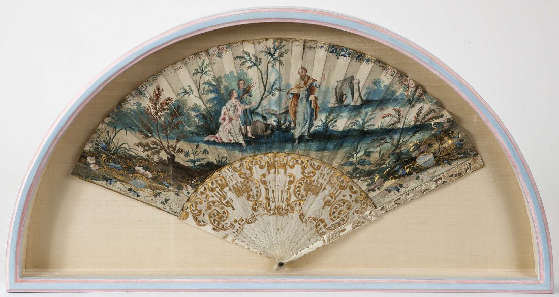 CONTINENTAL SCHOOL, EARLY 19TH CENTURY : CONTINENTAL SCHOOL, EARLY 19TH CENTURY A painted fan with a lady and gentleman bringing wood to a hermit in a river landscape, gouache on gold decorated ivory sticks. 11" x 20" (28cms x 51cms). (1).