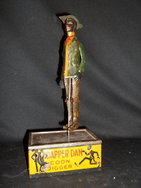 Antique Louis Marx Coon Jigger Dapper Dan: Nice antique Louis Marx Dapper Dan Coon Jigger tin and metal wind up toy. Dapper Dan dances when wound and has a nice petina. One arm is held on by later added wire, and initials AR are lightly carved