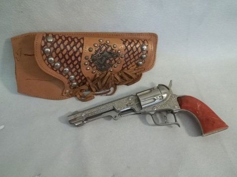 Hubley Cap Gun Pioneer 260 Caramel W Holster: Nice cowboy cap gun, some cracking in handle but does not go all the way across - hard to find grips - super graphics and engraving design on metal, functions well ... holster has a metal badge of a b