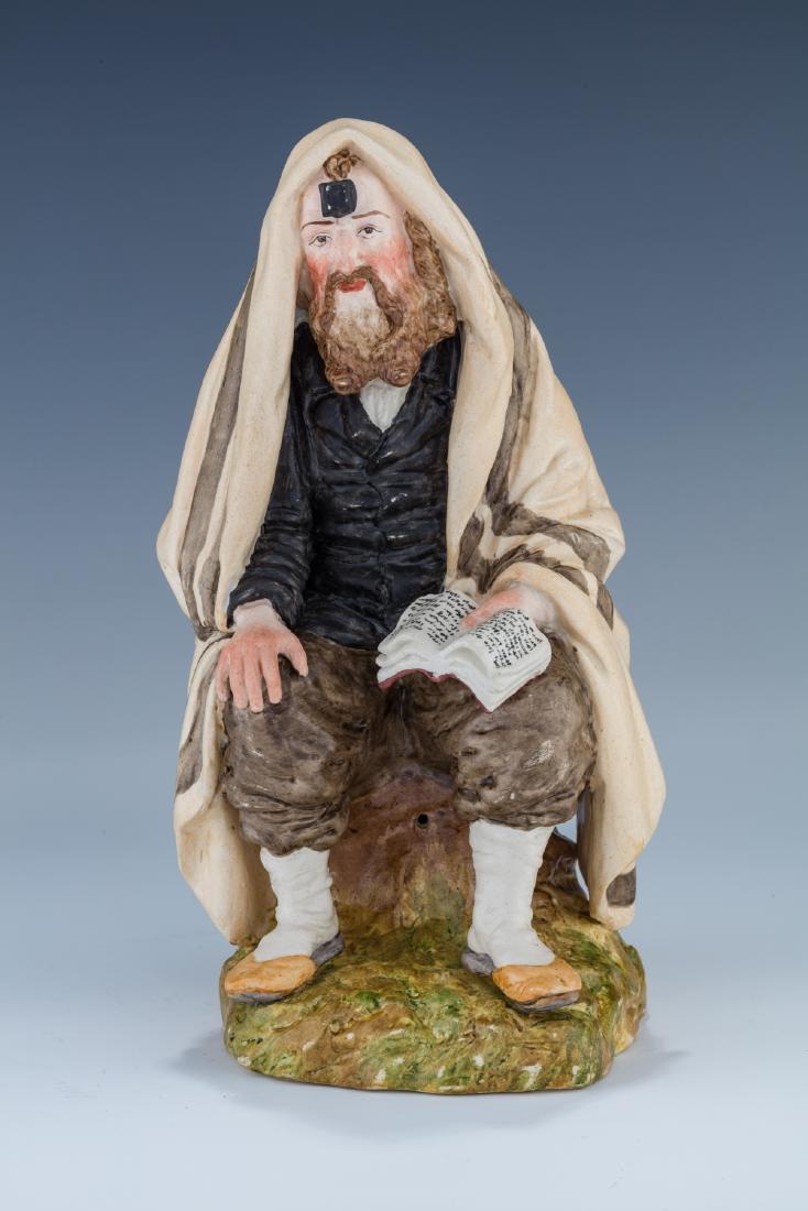A PORCELAIN FIGURINE OF A SEATED HASIDIC MAN IN PRAYER. (1 of 8)