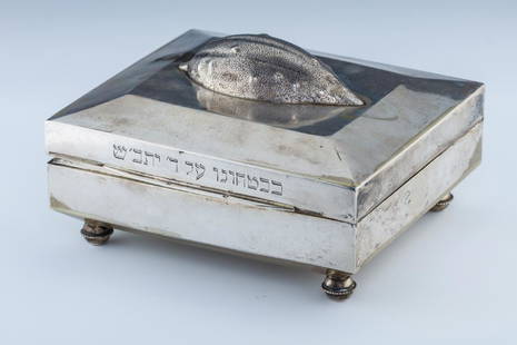 A LARGE SILVER ETROG BOX. Vienna, c.: A LARGE SILVER ETROG BOX. Vienna, c. 1890 In square shape, with realistically chased etrog on upper portion and Hebrew inscription along rim. Marked. 6.8" wide.