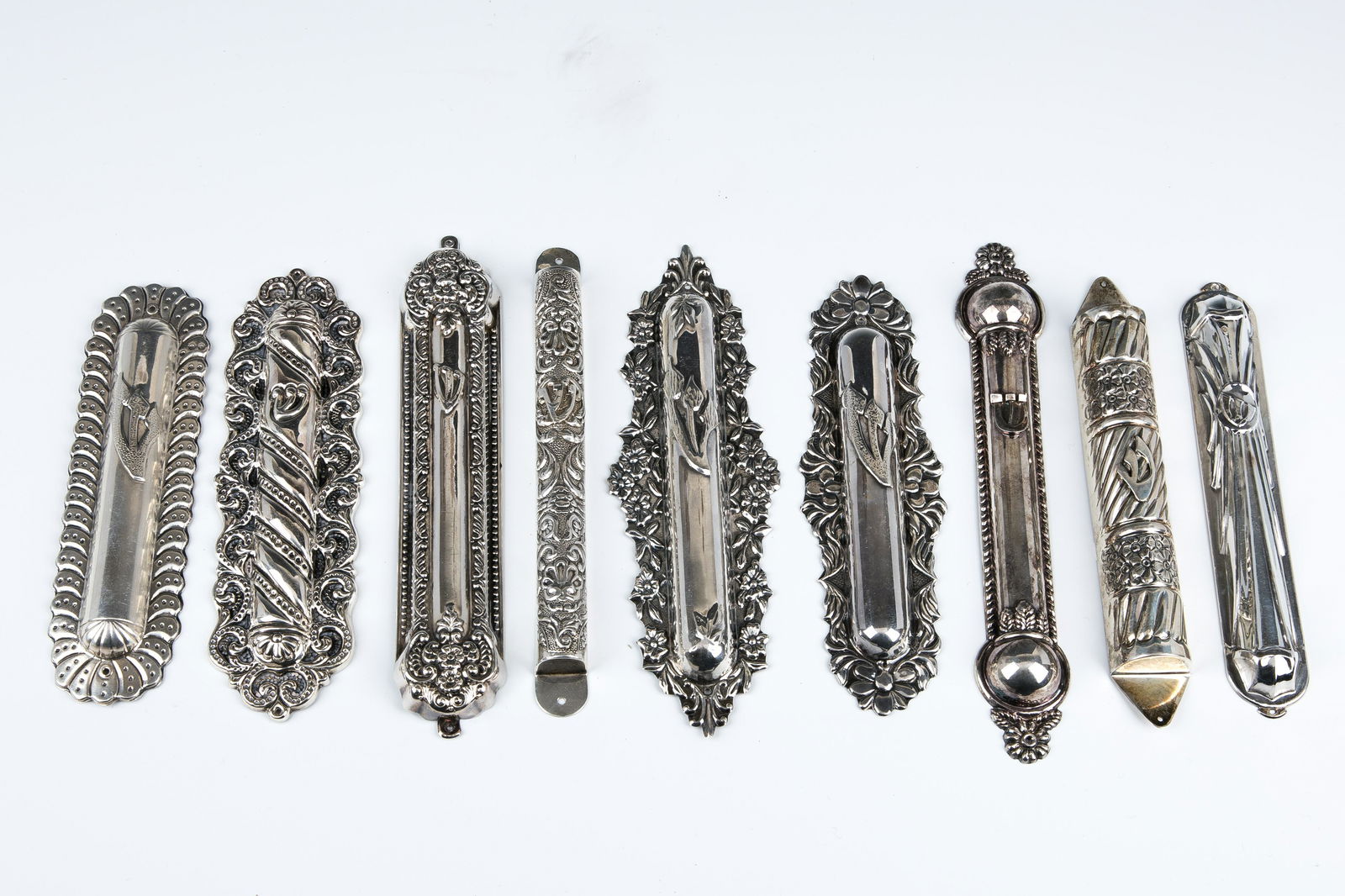 A COLLECTION OF NINE SILVER MEZUZAH COVERS. Various (1 of 1)