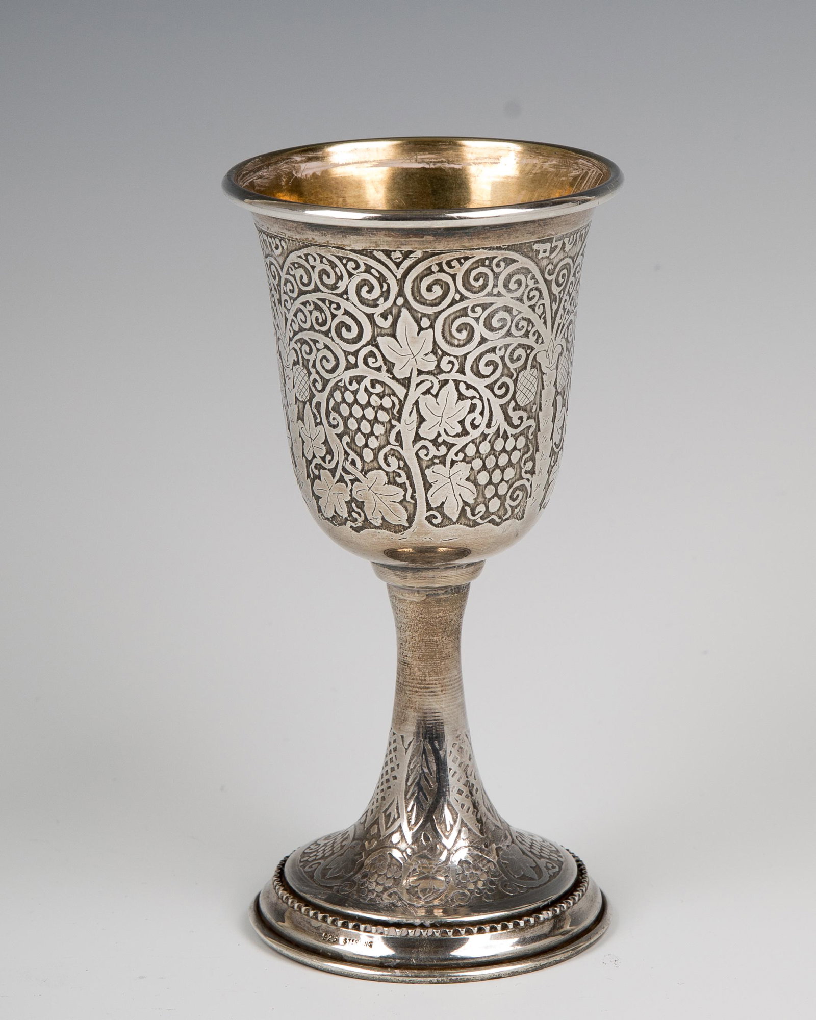42. A SILVER KIDDUSH GOBLET BY BEZALEL. Israel, c.: 42. A SILVER KIDDUSH GOBLET BY BEZALEL. Israel, c. 1950. On round base with acid etched designs. Engraved in Hebrew: there is no happiness without wine. 5.2" tall.