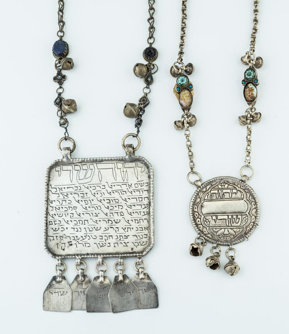 157. TWO LARGE SILVER AMULETIC NECKLACES. Middle: 157. TWO LARGE SILVER AMULETIC NECKLACES. Middle Eastern, 19th/20th centuries. The first circular (2”) and inscribed with G-d’s name. The second a stylized square (3.1” wide) engraved on both si