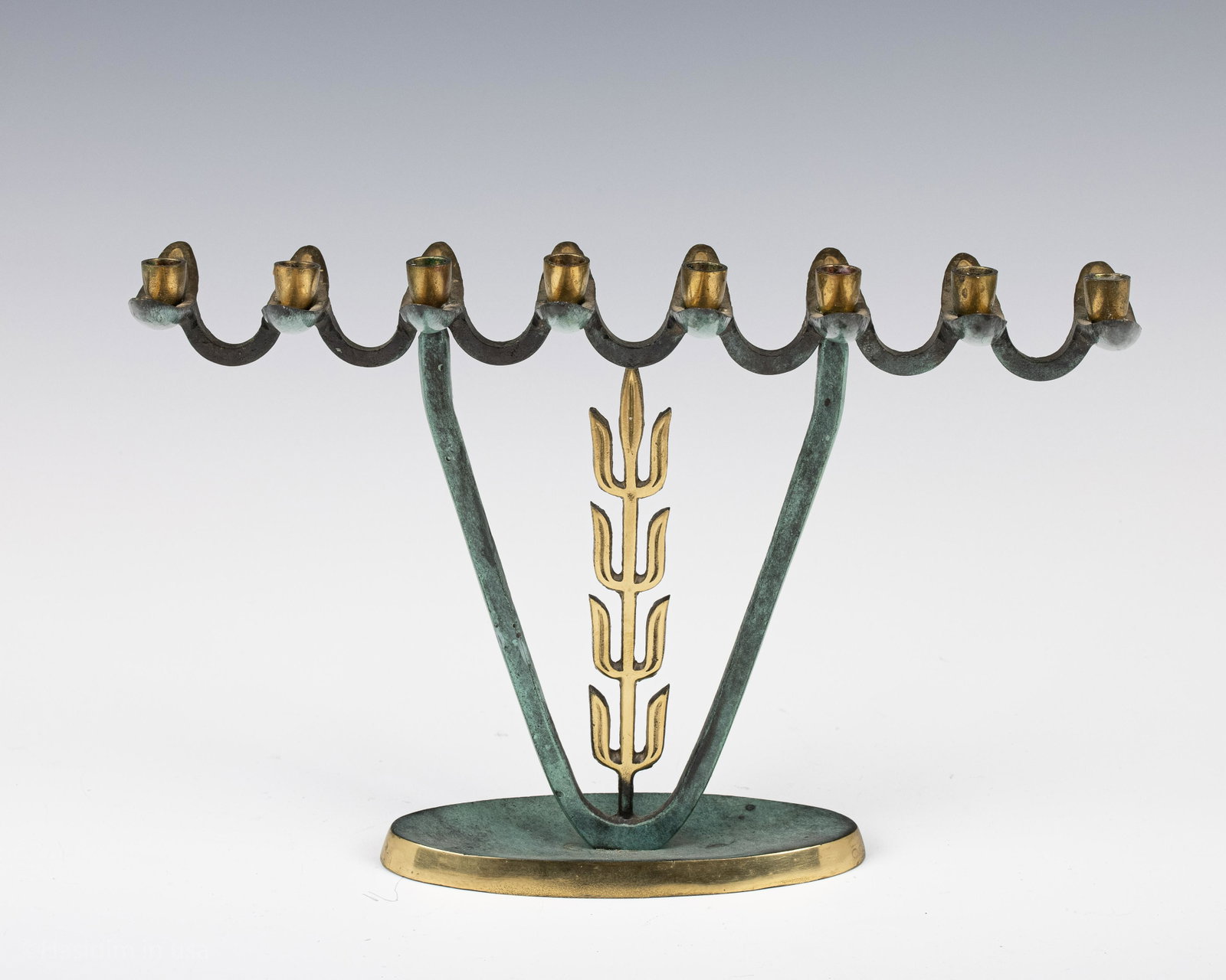 137. A HANUKKAH MENORAH. Israel, c. 1960. Traditional: 137. A HANUKKAH MENORAH. Israel, c. 1960. Traditional form on oval base and patinated green paint. 10.5” wide.