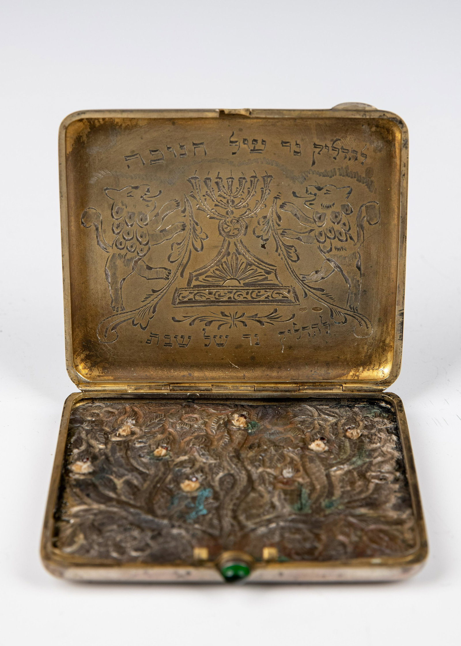 A SILVER CIGARETTE BOX CONVERTED TO A TRAVELING MENORAH: 220. A SILVER CIGARETTE BOX CONVERTED TO A TRAVELING MENORAH. 20th century. 4.2 x 3.7".