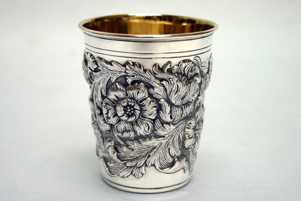 A SILVER KIDDUSH BEAKER BY TIFFANY.: Portugal, c. 1990. With interior gilding. Chased with floral designs. 3.5" tall.