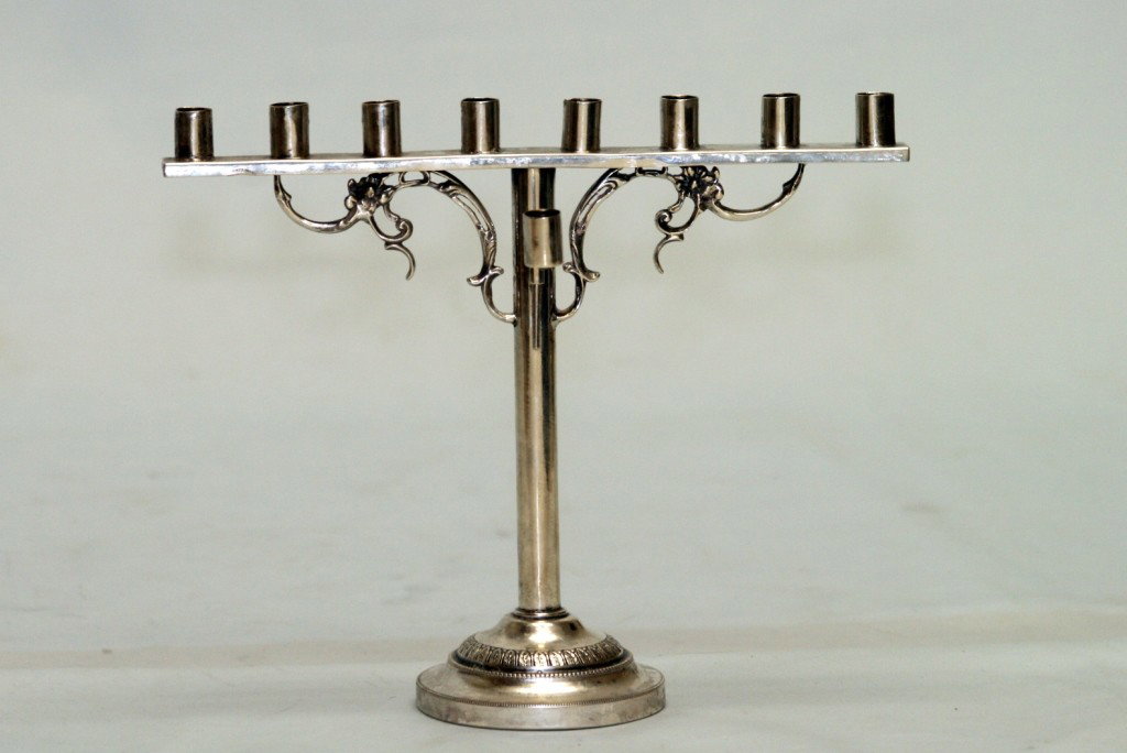 A SILVER MENORAH.: Germany, 19th century. On round machine tooled base with flat upper portion that supports 8 candle holders. 9" tall. Marked crown moon and 800.