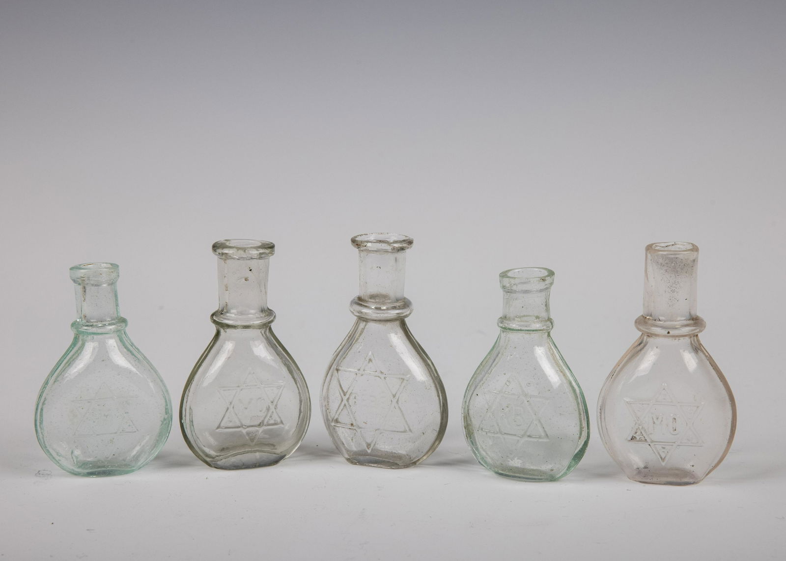 A GROUP OF 5 SMALL JUDAICA SCHNAPPS FLASKS. C. 1900. Each marked with Jewish stars.: A GROUP OF 5 SMALL JUDAICA SCHNAPPS FLASKS. C. 1900. Each marked with Jewish stars.