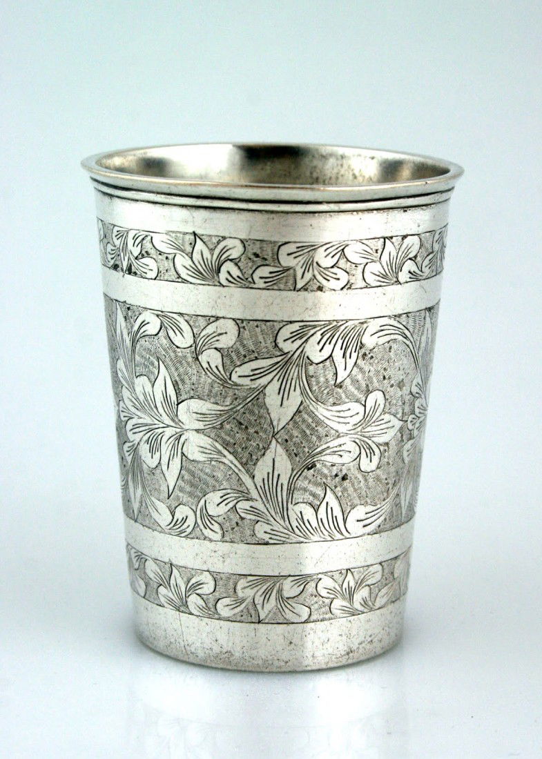 A LARGE SILVER KIDDUSH BEAKER. Poland, c. 1840. eng: A LARGE SILVER KIDDUSH BEAKER. Poland, c. 1840. engraved with organic and foliate designs. The base engraved with two Hebrew initials. 2.8" tall.