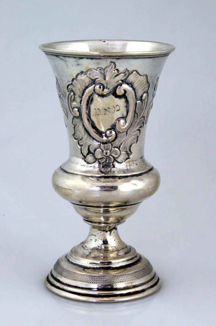 A LARGE SILVER KIDDUSH CUP. Vienna, c. 1840. Hand: A LARGE SILVER KIDDUSH CUP. Vienna, c. 1840. Hand chased with floral design. Engraved in center cartouche with Hebrew initials. Marked. 4.8" tall.