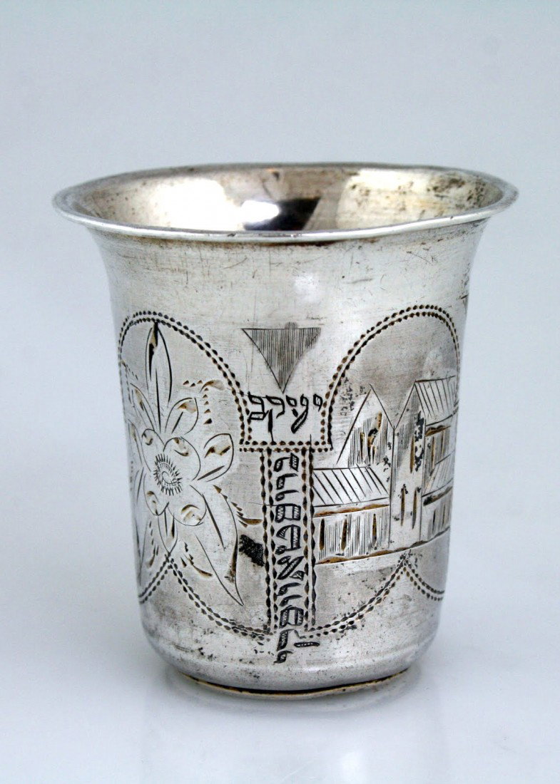 A SILVER KIDDUSH BEAKER. Russia, c. 1894. In typic: A SILVER KIDDUSH BEAKER. Russia, c. 1894. In typical shape. Engraved with houses and flowers. With former owner's Hebrew name "YAKKOV BRUSOFSKY". Marked. 2.2" tall.