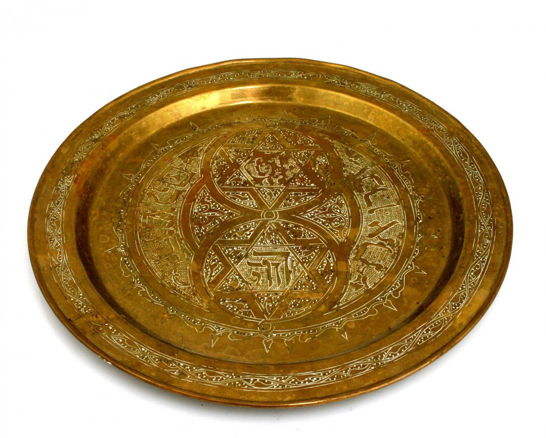 A BRASS CHARGER PLATE. Jerusalem, c. 1900. Engrave: A BRASS CHARGER PLATE. Jerusalem, c. 1900. Engraved with Middle Eastern decoration and "Remember Jerusalem". 12" wide.