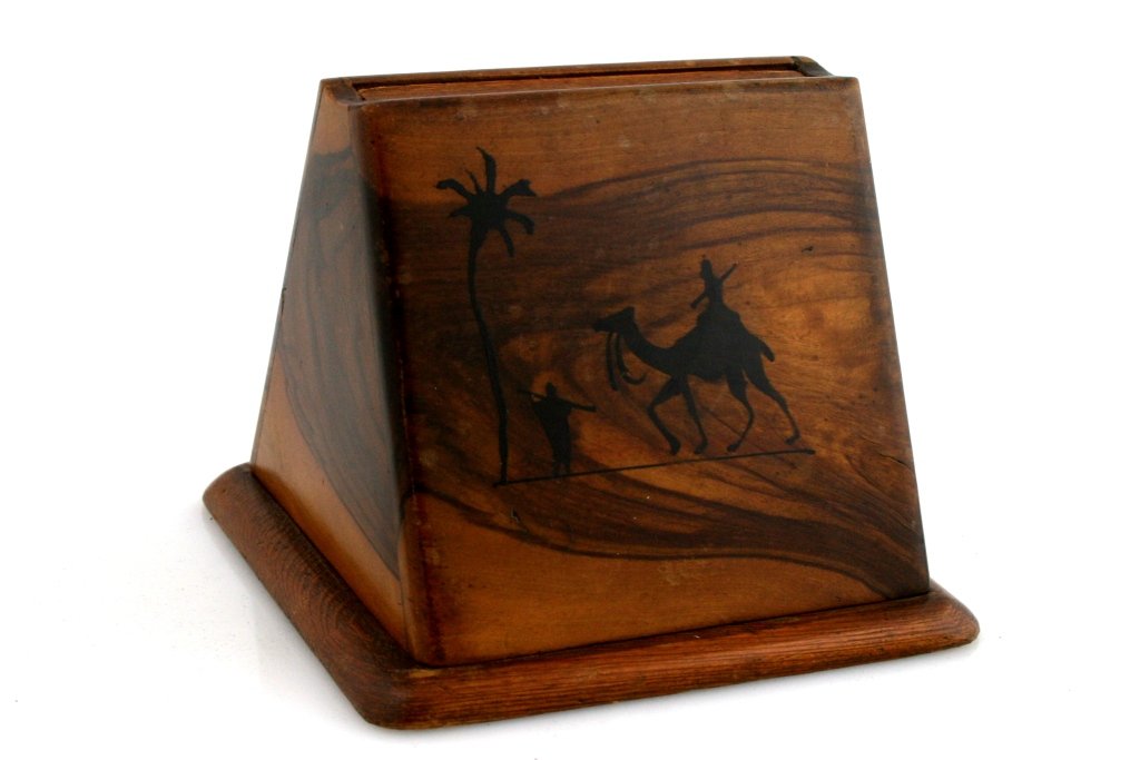 AN OLIVEWOOD CIGARETTE HOLDER. Palestine, c. 1920.: AN OLIVEWOOD CIGARETTE HOLDER. Palestine, c. 1920. triangular in shape. Decorated with silhouette of middle eastern man on a camel. 3.8” tall.