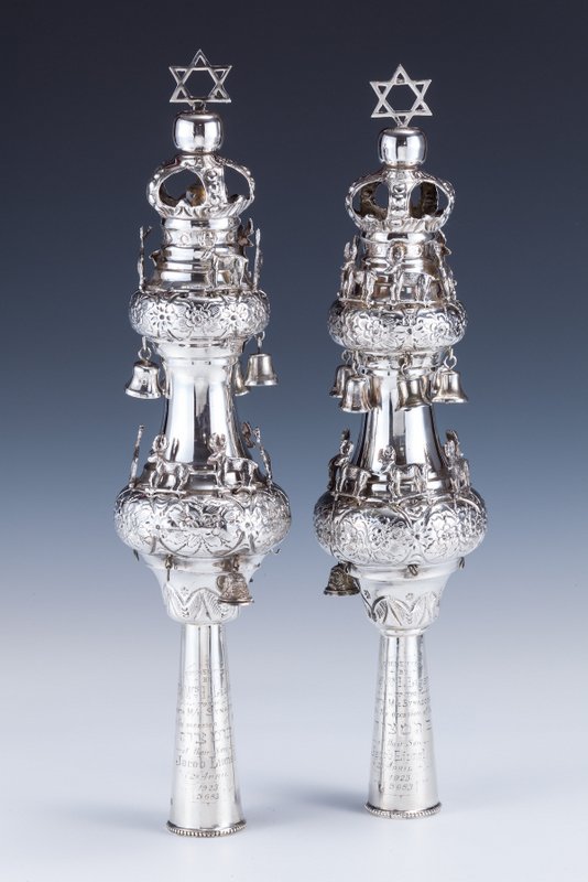 A LARGE PAIR OF STERLING SILVER TORAH FINIALS BY M: A LARGE PAIR OF STERLING SILVER TORAH FINIALS BY MOSES SALKIND. London, 1922. Decorated with floral chasing. Fitted with stags and bells. Engraved in English: “PRESENTED BY MR & MRS LAGERMAN TO THE 