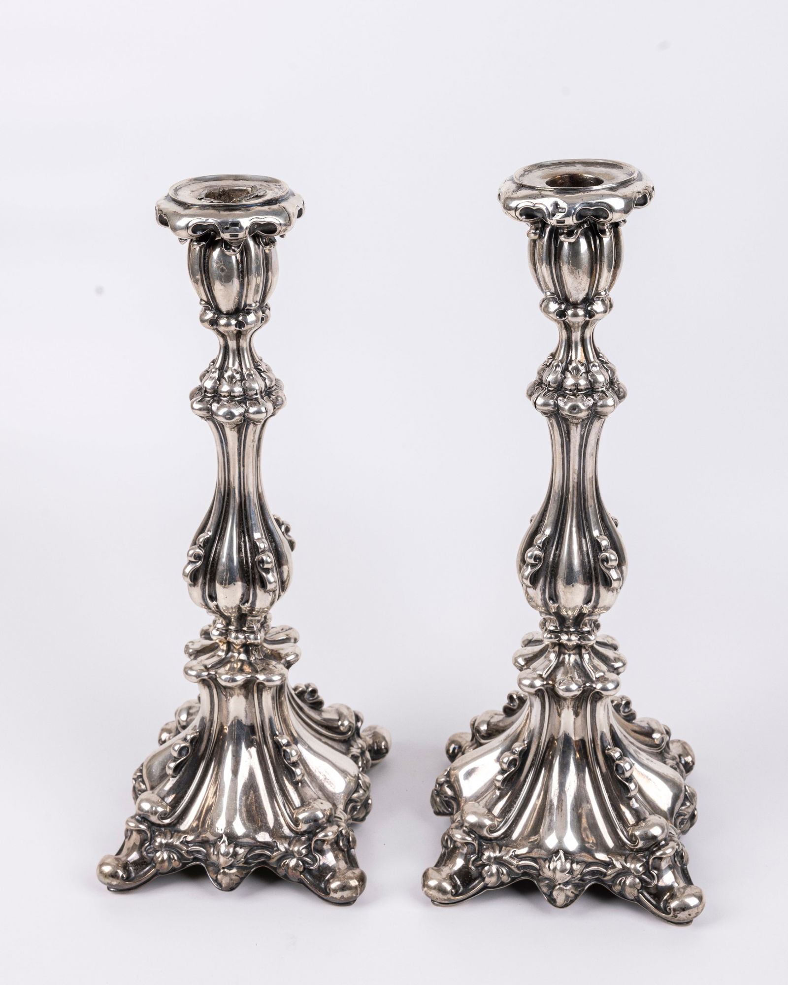 A PAIR OF SILVER CANDLESTICKS. Germany, c. 1890. The bases are embossed with floral designs. Some (1 of 6)