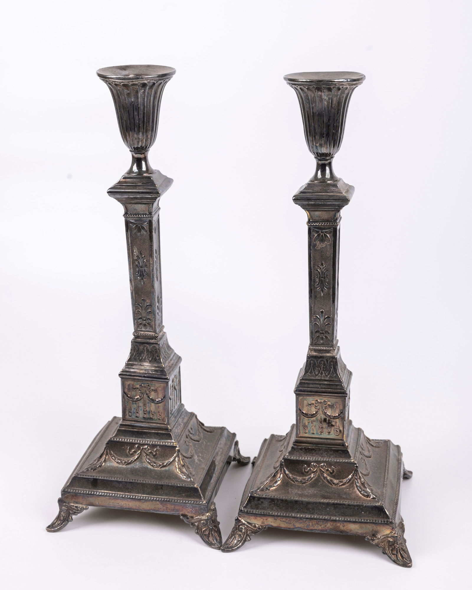 A LARGE PAIR OF BRASS SABBATH CANDLESTICKS. Warsaw, c. 1900. On square bases, embossed with floral (1 of 1)