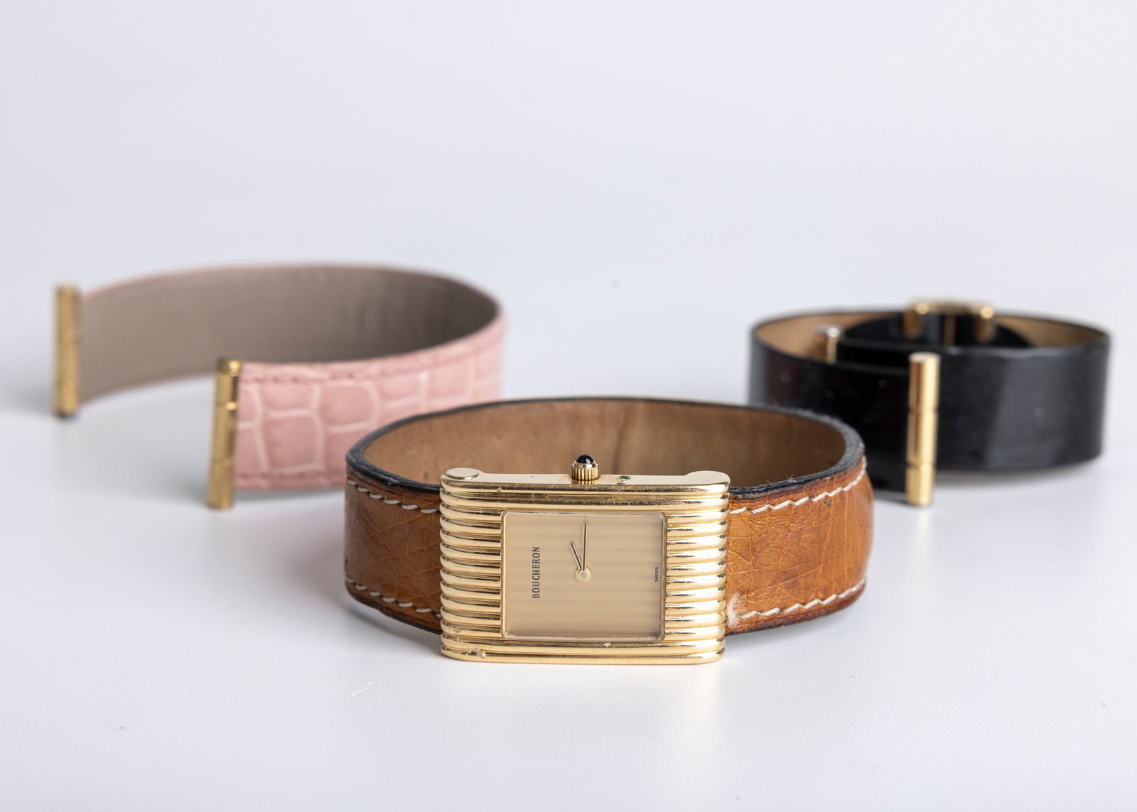 AN 18K GOLD BOUCHERON WRISTWATCH. With a tan worn Boucheron band. The watch is marked B BOUCHERON 18 (1 of 6)