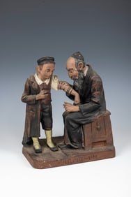 A CERAMIC FIGURINE OF A BAR MITZVAH. Probably Czechoslovakia, c. 1920. Depicting a man instructing a