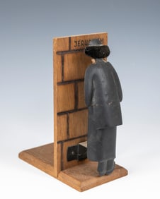 A PRAYING JEW WOODEN FIGURE. Jerusalem, c. 1960. A depiction of the Kotel with a swaying hasidic Jew