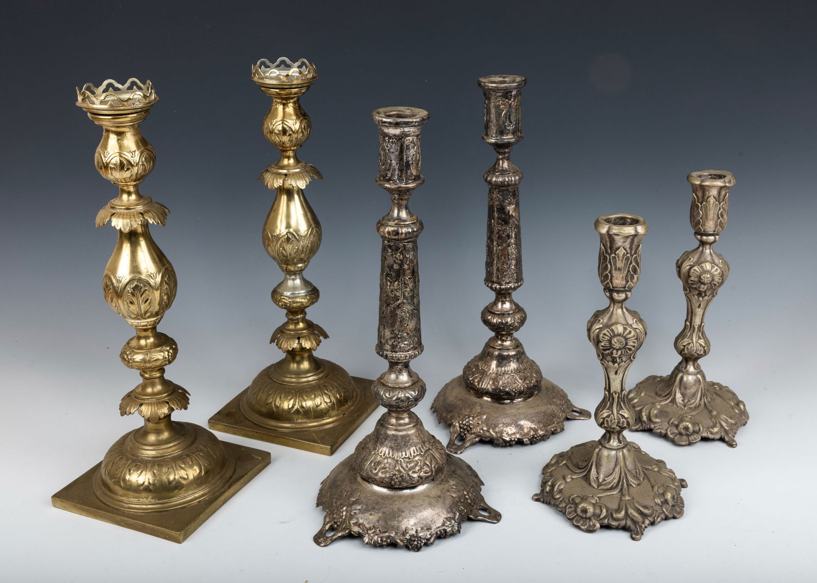 A GROUP OF THREE PAIRS OF SABBATH CANDLESTICKS. Poland, c. 1880. Each of them has a different style.: A GROUP OF THREE PAIRS OF SABBATH CANDLESTICKS. Poland, c. 1880. Each of them has a different style. Marked. The largest is 14” tall.