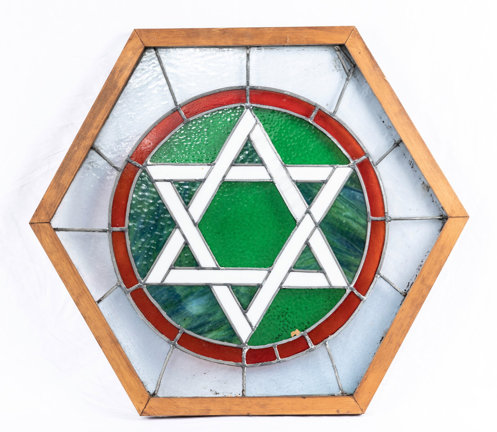 A STAINED GLASS JEWISH STAR FROM A SYNAGOGUE. American, c. 1920. In an octagonal wooden frame. 28: A STAINED GLASS JEWISH STAR FROM A SYNAGOGUE. American, c. 1920. In an octagonal wooden frame. 28” wide.
