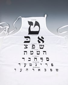 A VINTAGE YIDDISH EYE CHART APRON. New York, Mid 20th century. Printed with a Yiddish eye chart.