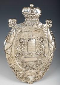 A SILVER TORAH SHIELD. Vienna, c. 1900. Oval form. Embossed with a pair of lions flanking an