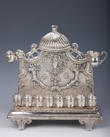 A LARGE SILVERPLATED HANUKKAH LAMP. In viennese style. Hand chased backplate on a rectangular