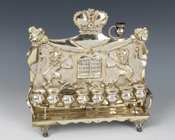A LARGE SILVER HANUKKAH LAMP. Vienna, 1890. On four scrolling feet. The backplate chased with the