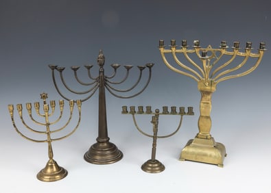 A GROUP OF FOUR BRASS MENORAHS. Germany, c. 1920. All in traditional form.