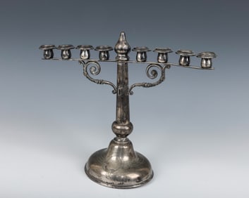 A SILVER MENORAH. Germany, c. 1900. On a round base with an engine turned design. 11?? wide.